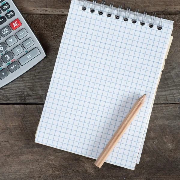 Table de bureau avec stylo, calculatrice et papier vide — Photo