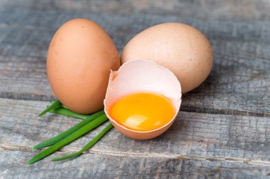 Bütün ve kırık kahverengi yumurta taze soğan ile