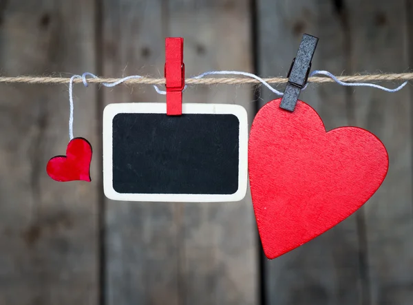 Foto instantánea en blanco y pequeños corazones de papel rojo —  Fotos de Stock