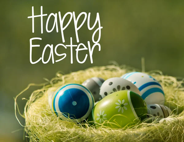 Œufs de Pâques dans le panier wisker dans la nature avec le texte Joyeux Pâques — Photo