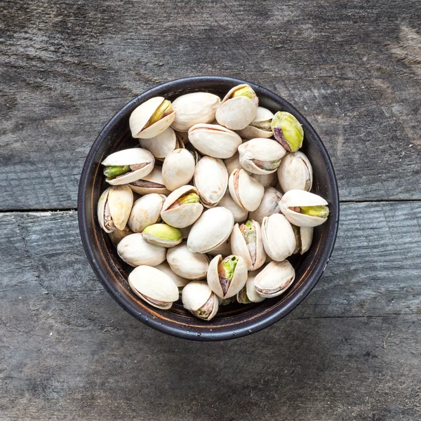 Pistachios in wooden bowl — Stock Photo, Image