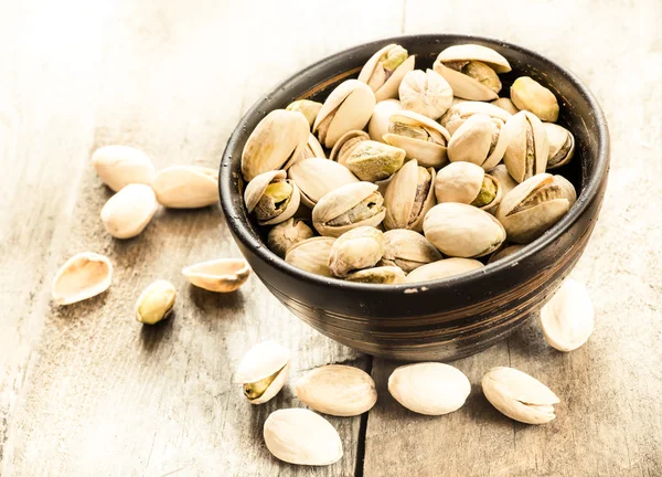 Pistachios in wooden bowl — Stock Photo, Image