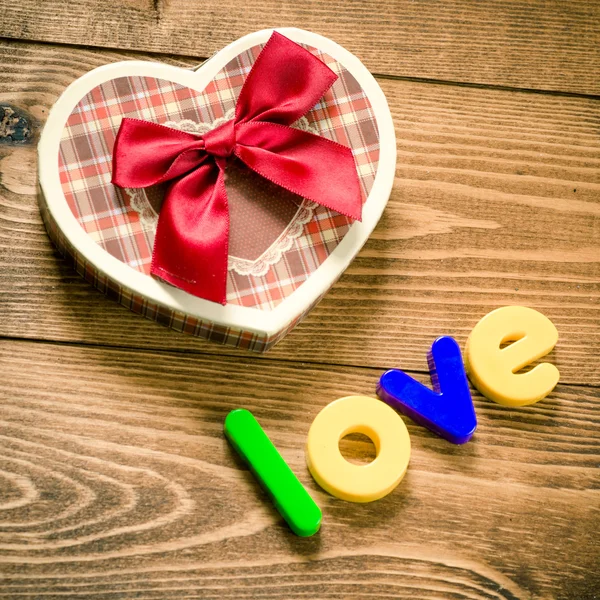 Woord liefde met hartvormige Valentijnsdag geschenkdoos — Stockfoto