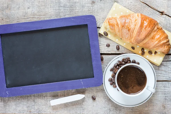 Tableau noir avec croissant et café — Photo