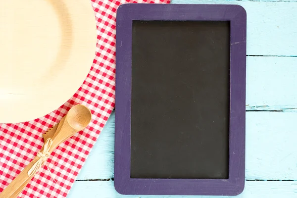 Blackboard on wooden surface — Stock Photo, Image