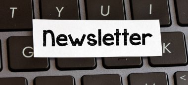 NEWSLETTER beyaz bir kağıt parçası üzerinde klavyede yatıyor.