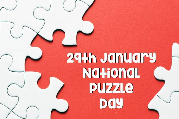 赤の背景にジグソーパズルと全国パズルの日のテキスト 教育と休日の概念 — ストック写真