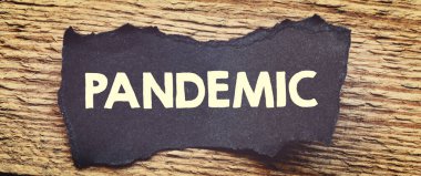 Pandemic kelime küçük kağıt parçaları ve ahşap bir masa üzerine yazılmış.