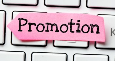 Klavyede duran pembe bir kağıt parçasında promosyon.