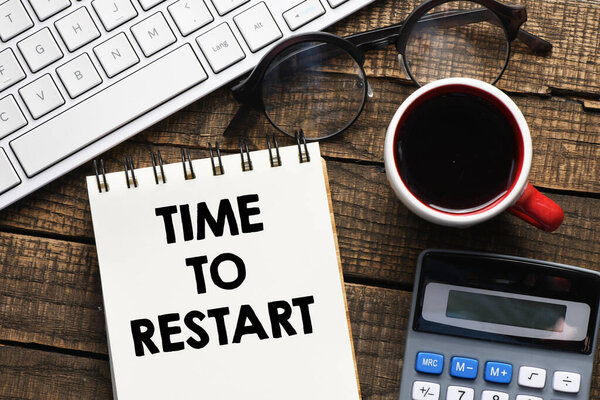 TIME TO RESTART text written in an office notebook.