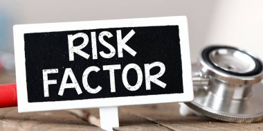 RISK FACTOR kelimeler steteskopun yanında küçük bir tebeşir tahtası üzerinde.
