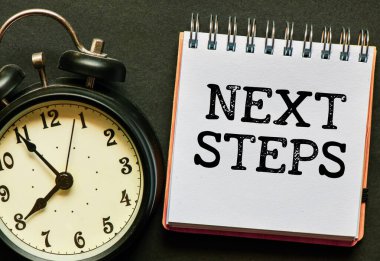 Bir ofis defterinde NİXT STEPS kelimeleri.