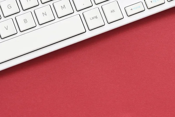 在红色背景上关闭白色计算机键盘 从上面看 — 图库照片