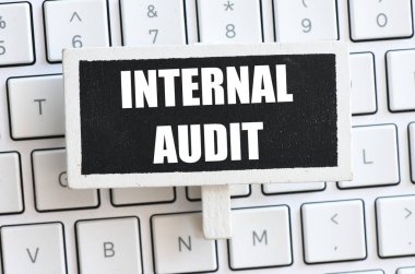 Bir bilgisayar klavyesinde bulunan küçük bir karatahtadaki INTERNAL AUDIT sözcükleri.