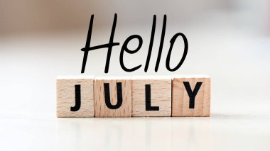 Hafif bir arkaplan üzerinde küçük bir tebeşir tahtasında JULY kelime.