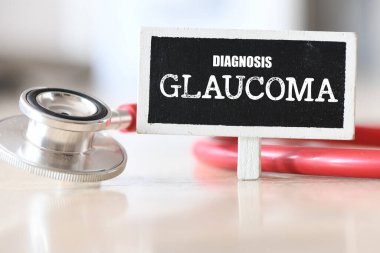 Steteskopun yanında küçük bir tebeşir tahtasında GLAUCOMA kelimesi.