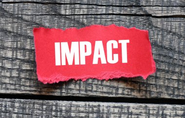 Küçük bir kırmızı kart ve ahşap arka planda çarpma kelimesi.