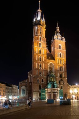 Krakow, Polonya - 22.. 06.2022. Geceleri Krakow 'daki St. Mary Bazilikası ve Pazar Meydanı, Polonya.