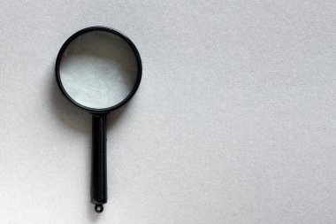 Gri arkaplanda siyah büyüteç.