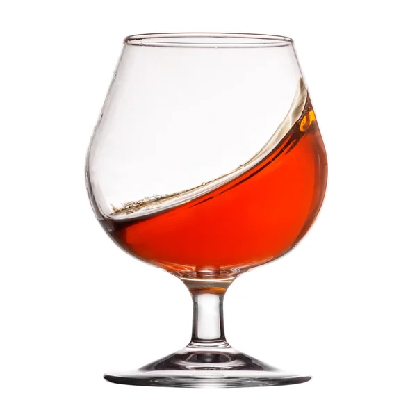 Splash of cognac in glass on white background — Stock Photo, Image