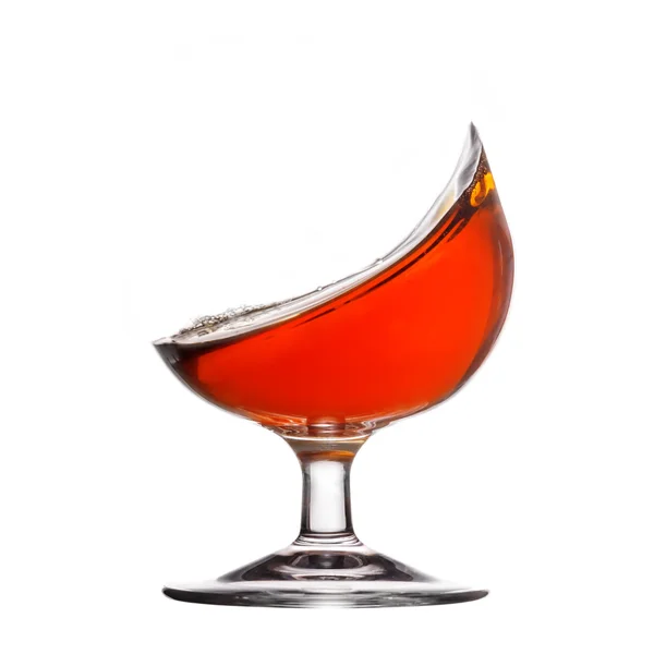 Spritzer Cognac im Glas auf weißem Hintergrund — Stockfoto