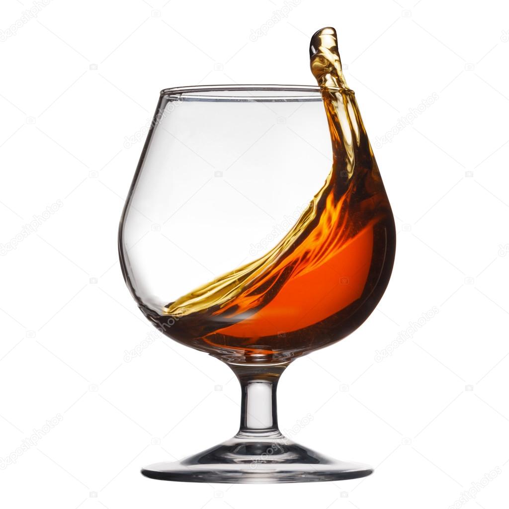 Splash of cognac in glass on white background