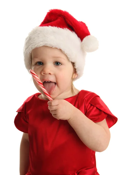 Dziecko jedzenie trzciny cukrowej candy w kapeluszu, santa — Zdjęcie stockowe