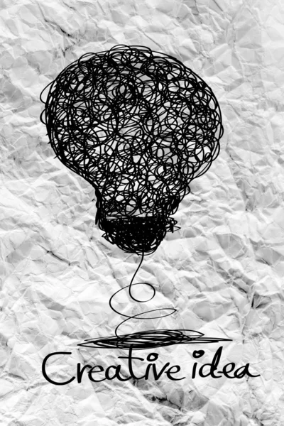 Idea concept light bulb on crumpled paper — Stock Photo, Image