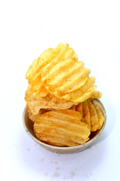 Вкусные картофельные чипсы в миске на белом фоне — стоковое фото
