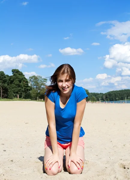 Leuk meisje, zittend op het strand — Stockfoto