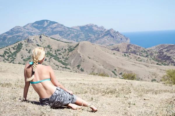Κορίτσι που κάθεται και κοιτάζοντας τη θάλασσα, τα βουνά — Φωτογραφία Αρχείου