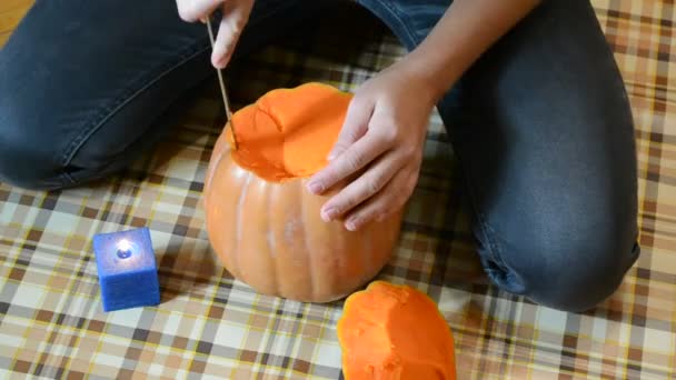 Person skär en pumpa till halloween — Stockvideo