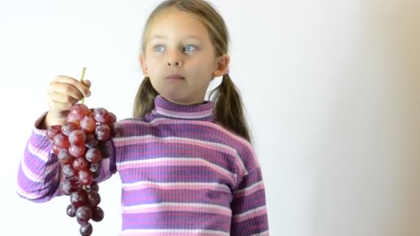 Маленькая девочка ест виноград — стоковое видео