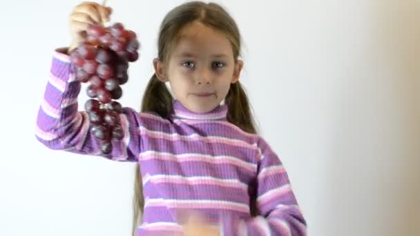 Маленькая девочка ест виноград — стоковое видео
