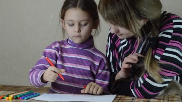 Мать и дочь рисуют ручки на белой бумаге — стоковое видео