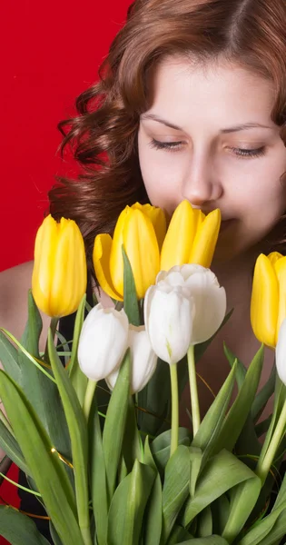 背景が赤いチューリップの花束を持つ少女 — ストック写真