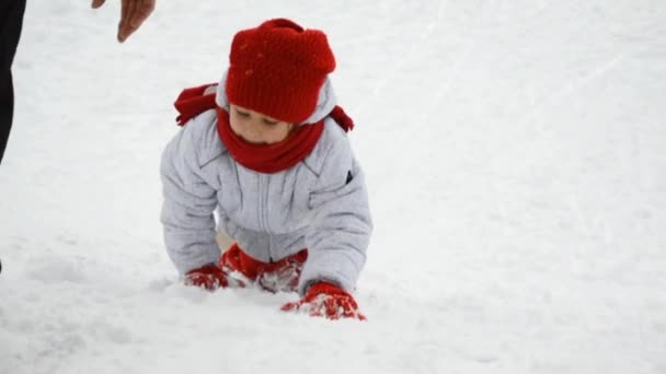 Flicka klättring en snöig backe — Stockvideo