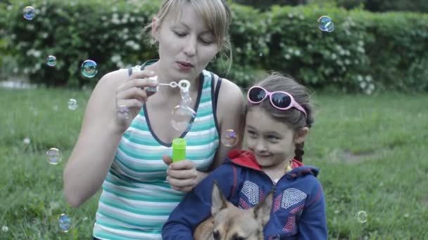 Madre e hija soplan burbujas de jabón — Vídeo de stock