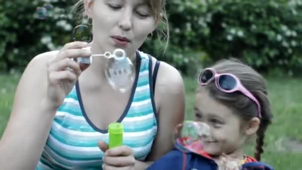 Mother and daughter blow soap bubbles — Stock Video