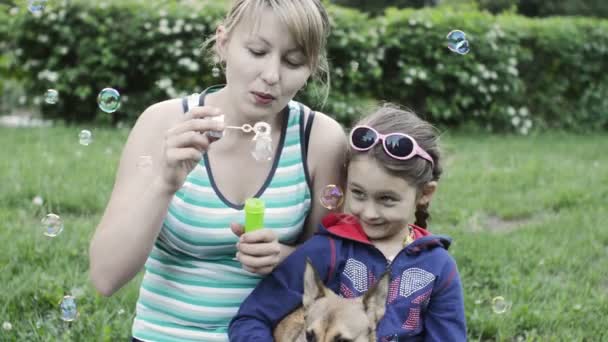 Mother and daughter blow soap bubbles — Stock Video