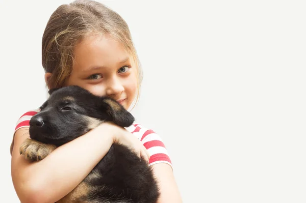 Niña abrazando a un cachorro pastor alemán —  Fotos de Stock