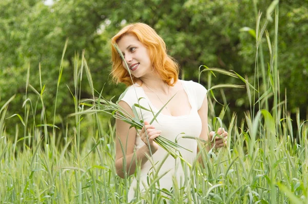 Belle fille marchant à travers un champ de blé — Photo