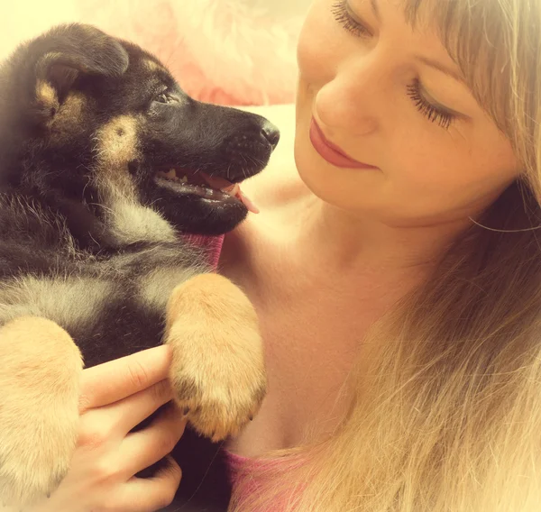 Mujer joven sosteniendo un cachorro pastor alemán —  Fotos de Stock