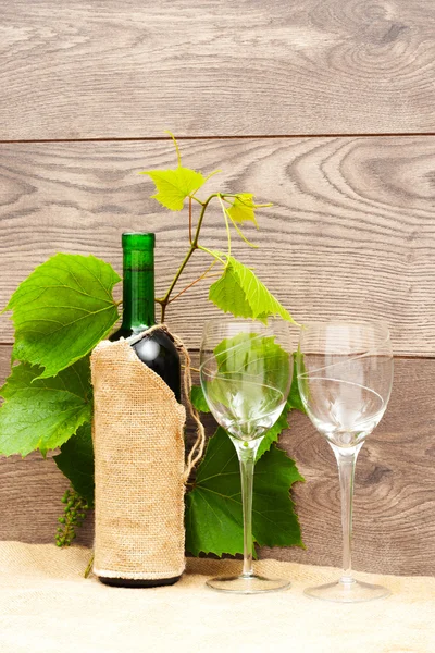 瓶酒和两个眼镜的一个木制的背景 — 图库照片