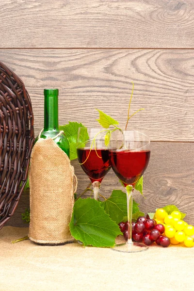 Vino e frutta e cesto di vimini su sfondo di legno — Foto Stock