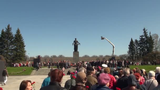 Deitado flores no monumento — Vídeo de Stock