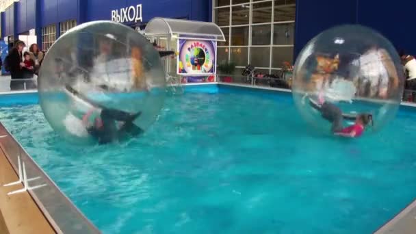 Children in spheres on water — Stock Video