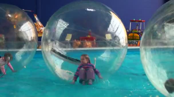 Children in spheres on water — Stock Video