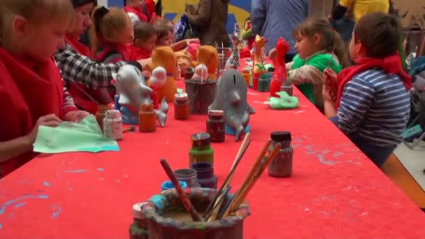 Dzieci siedzą wokół biurka, ciesząc się obraz z kolorami w sztuce — Wideo stockowe