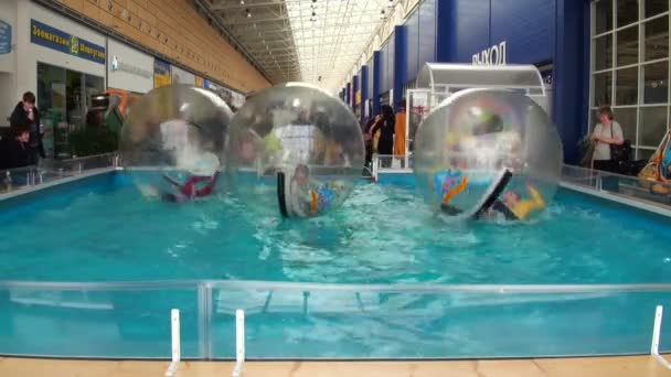 Children in spheres on water — Stock Video